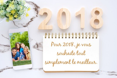Gelukkig nieuwjaar 2018 met foto in telefoon en tekst op notebook Fotomontage