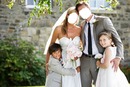 Bride And Groom With flower girl And Page Boy At Wedding Smiling To Camera
